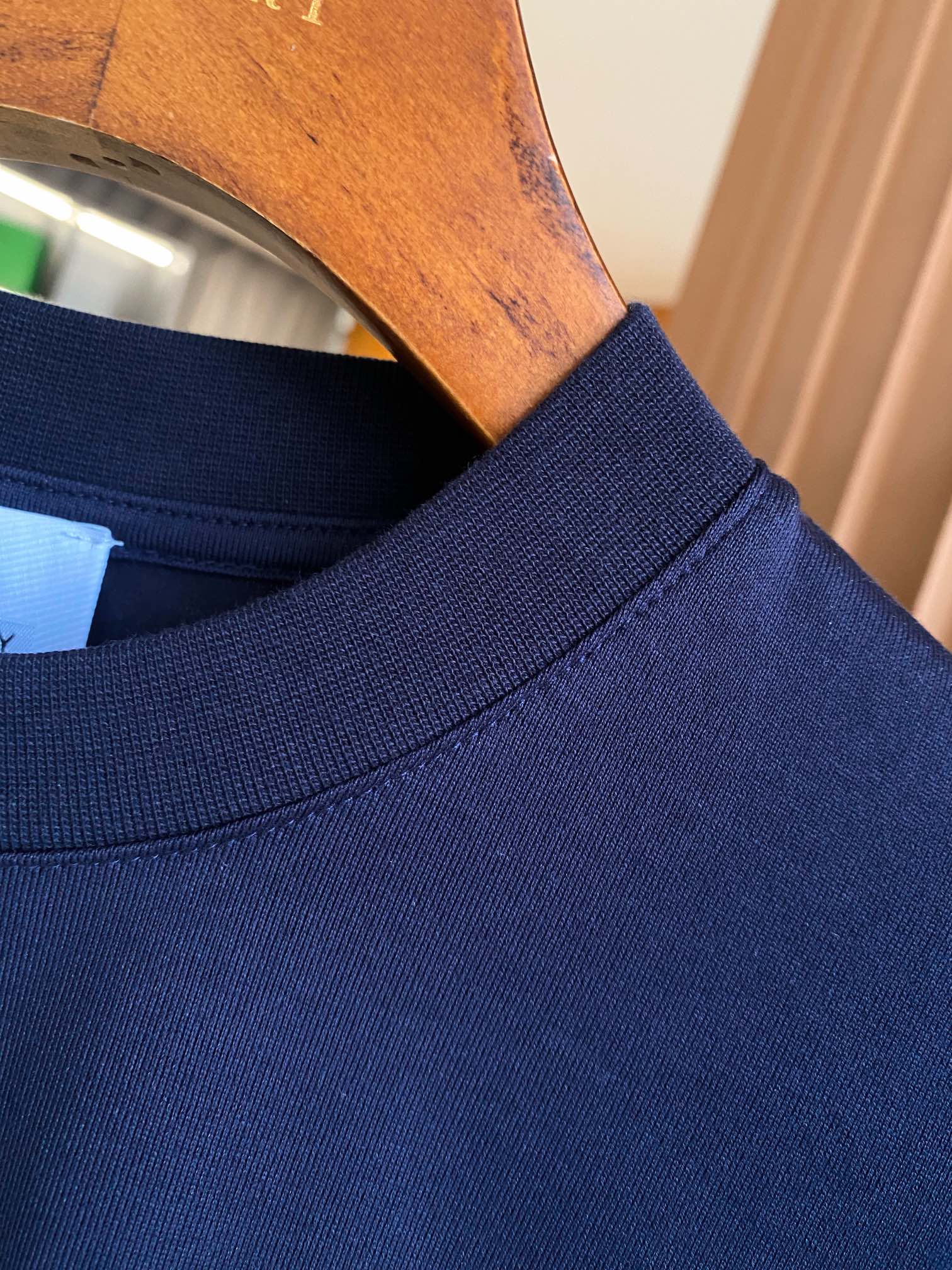 Navy crew-neck T-shirt neckline and collar seam detail.