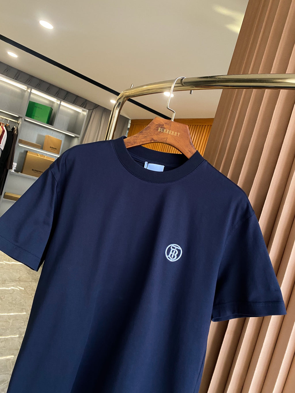 Navy short-sleeve T-shirt, crew neck, white logo emblem at left chest.