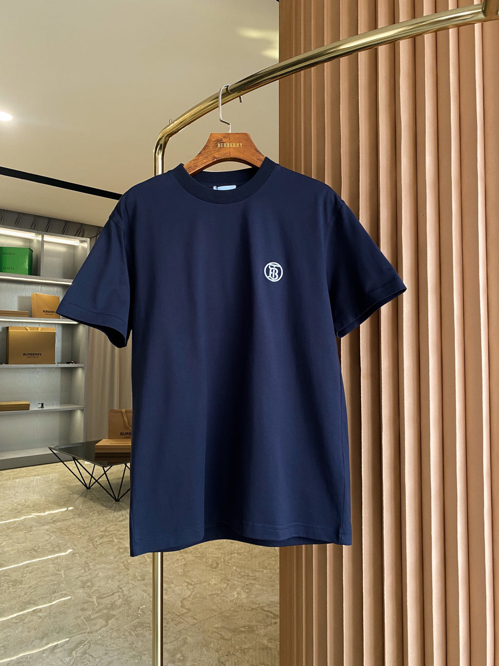 Navy short-sleeve crew-neck T-shirt with small white logo on chest.