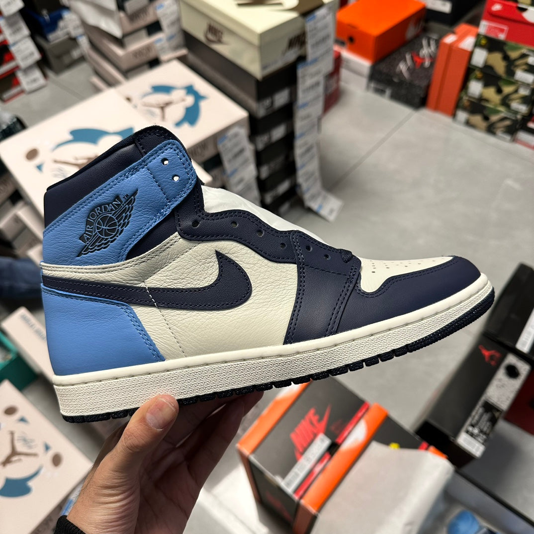 High-top Air Jordan 1 sneaker in navy, light blue, and white with side Swoosh
