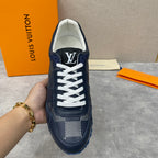 Navy Louis Vuitton low-top sneaker in hand, white laces, LV logo on tongue, blue sole