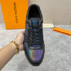 Black low-top sneaker held up showing tongue logo and iridescent toe panel.