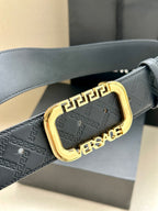 Versace belt with embossed logo print and gold-tone buckle on dark strap.