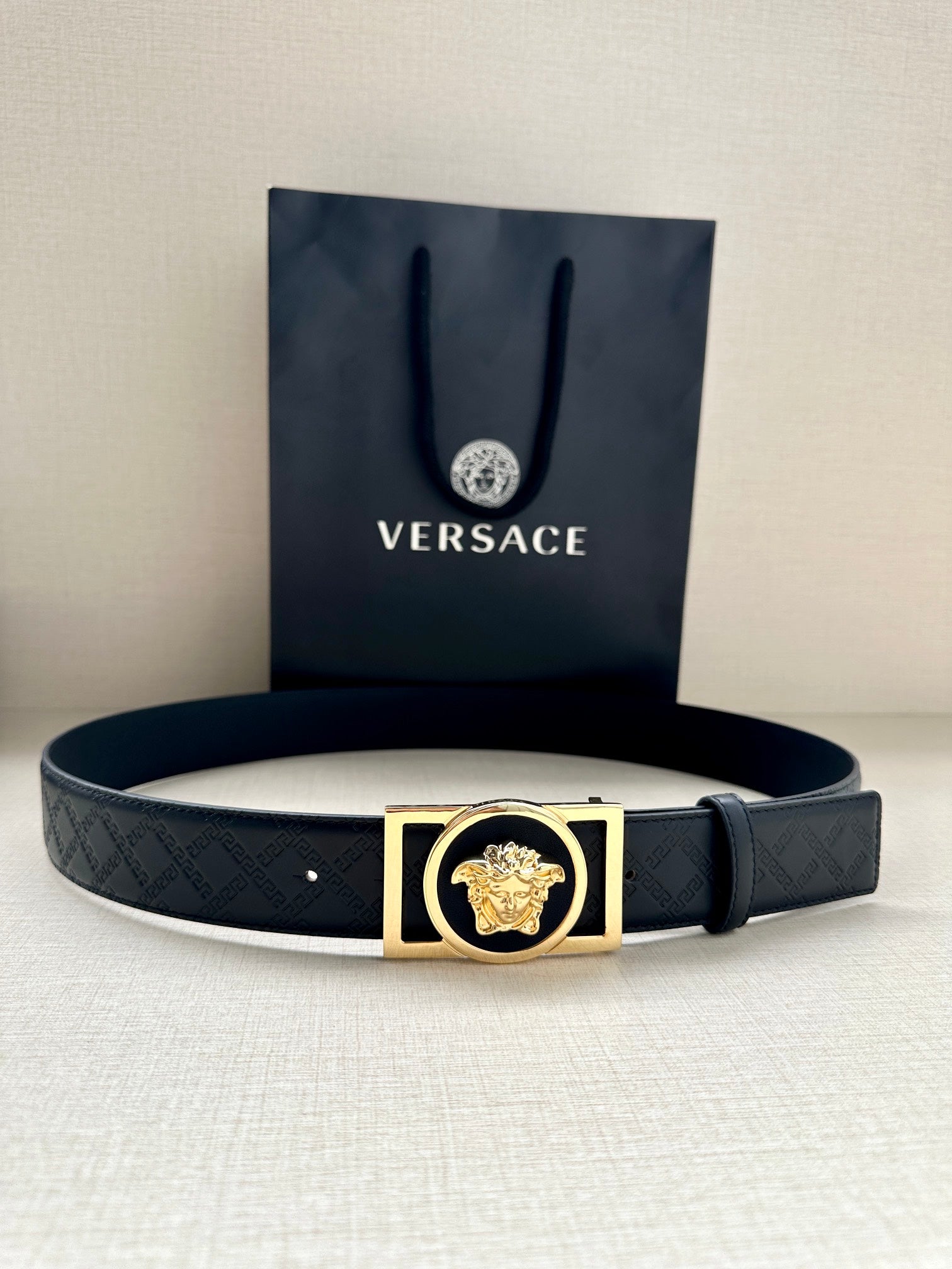 Versace belt with dark patterned strap and gold-tone rectangle buckle with lion emblem