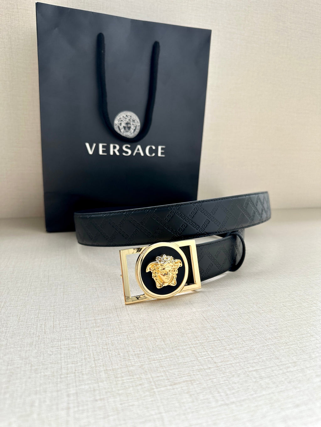 Versace belt with dark patterned strap and gold-tone rectangle buckle with lion emblem