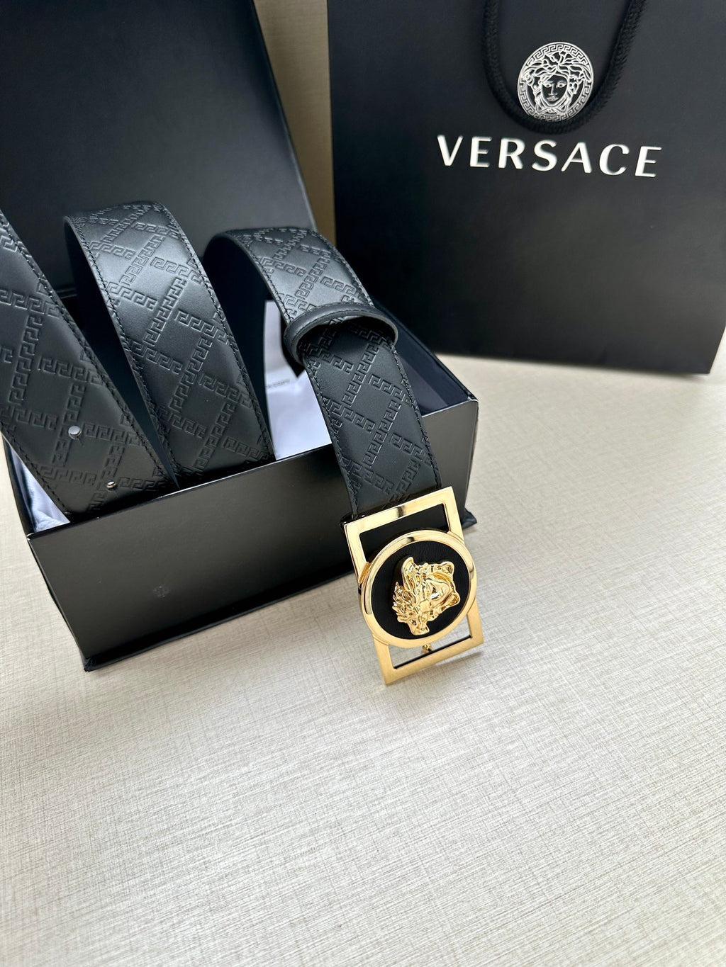 Versace belt with dark patterned strap and gold-tone buckle with lion emblem detail