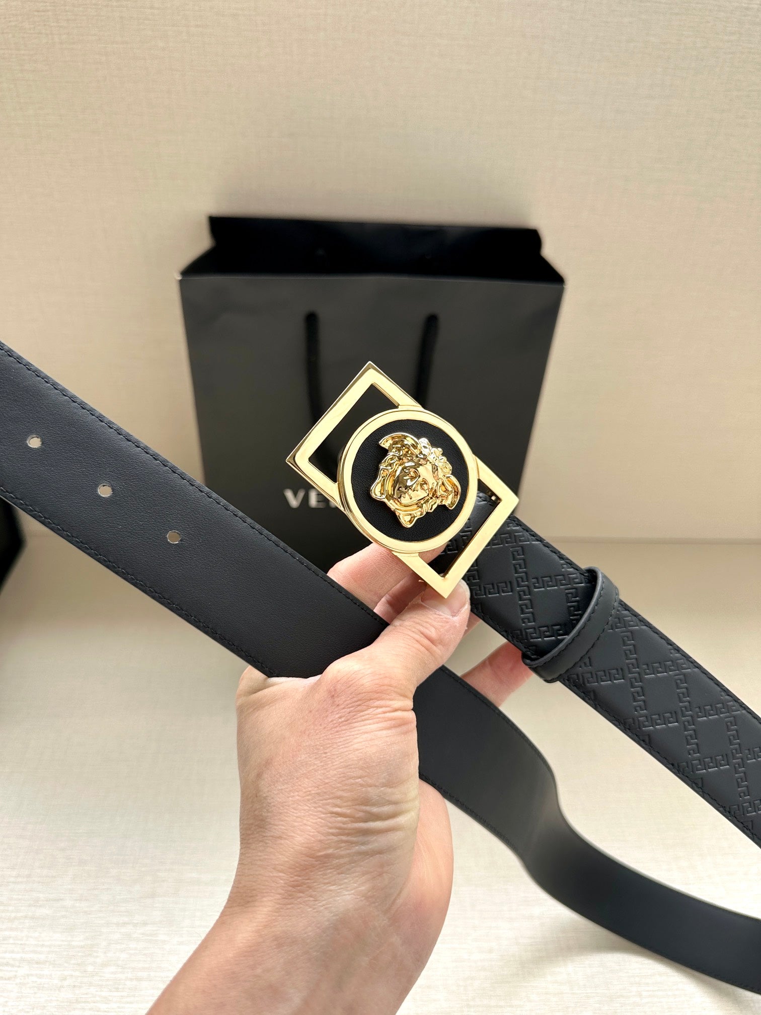 Versace belt with dark patterned strap and gold-tone square buckle with lion emblem
