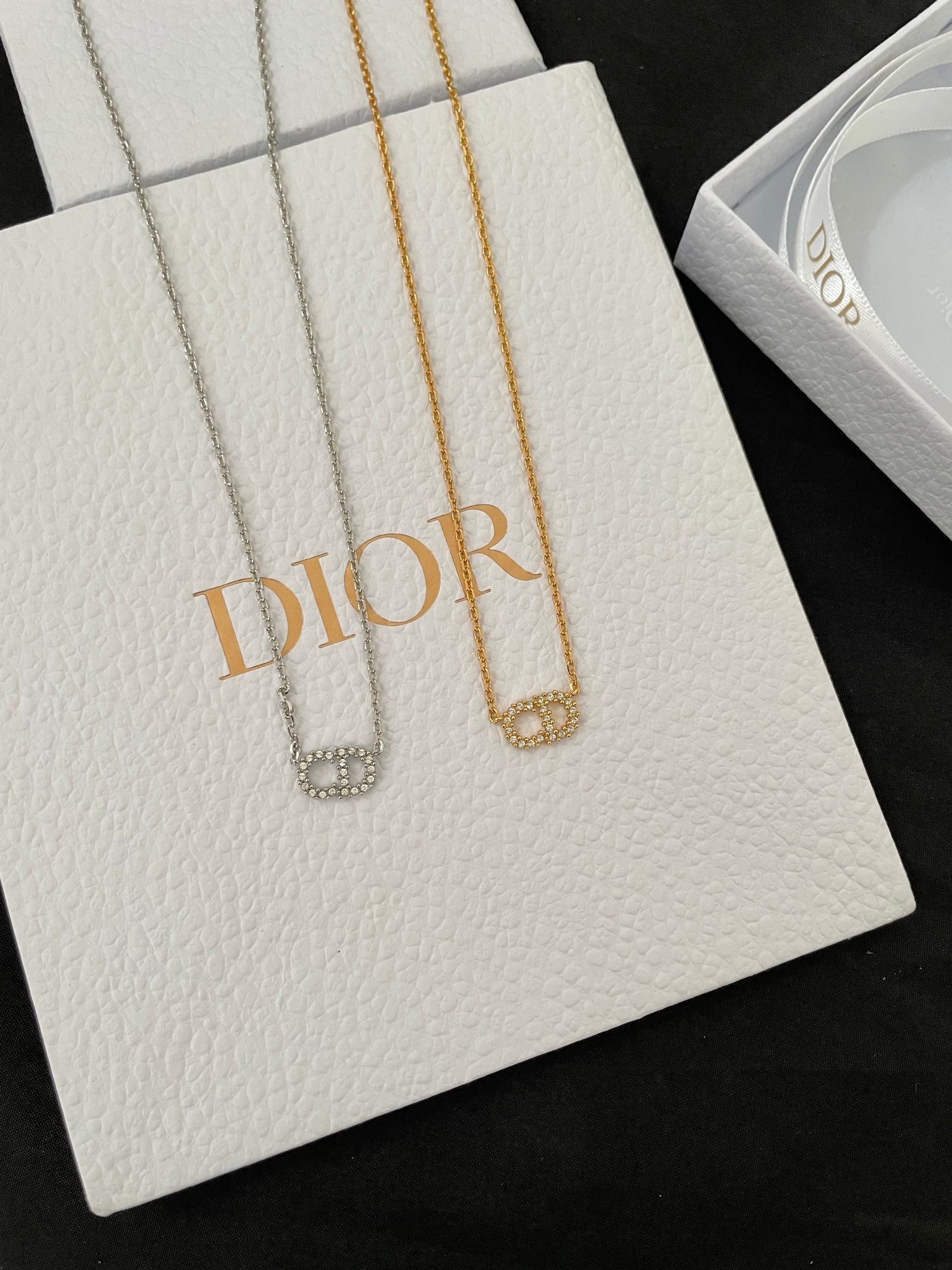 Silver-tone and gold-tone pendant necklaces on white gift cards