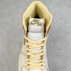 White high-top sneaker with yellow laces and padded tongue showing a logo patch.