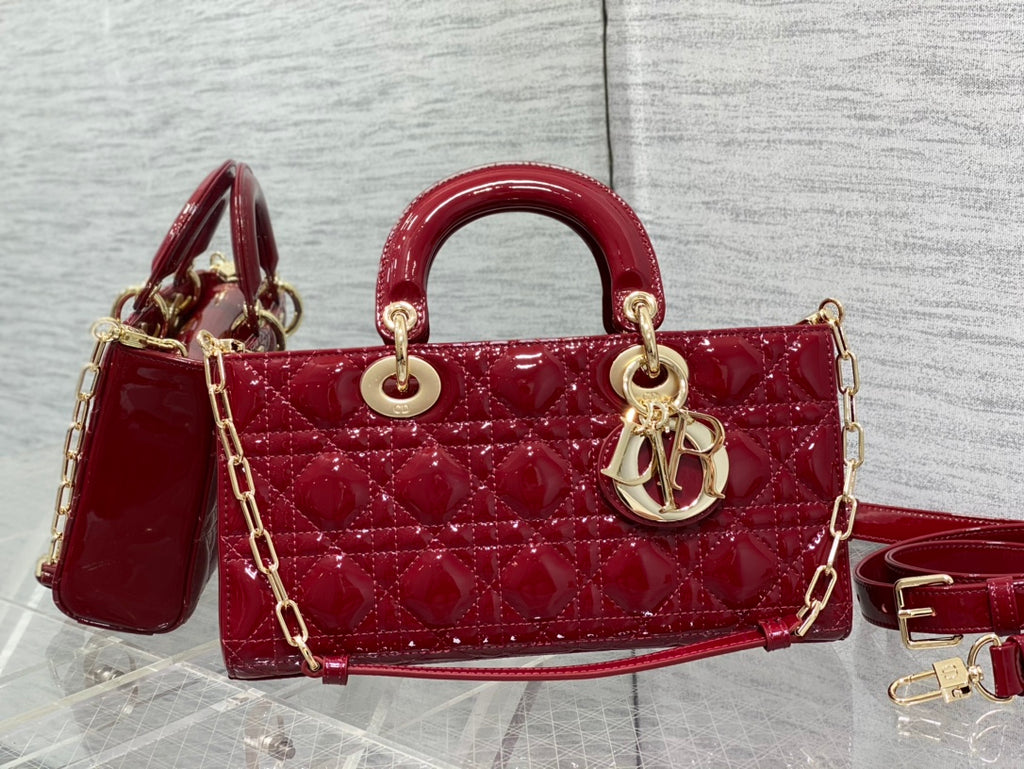 Dior handbag deep red with quilted front, curved handle, gold hardware and strap.