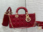 Dior handbag deep red with quilted front, curved handle, gold hardware and strap.