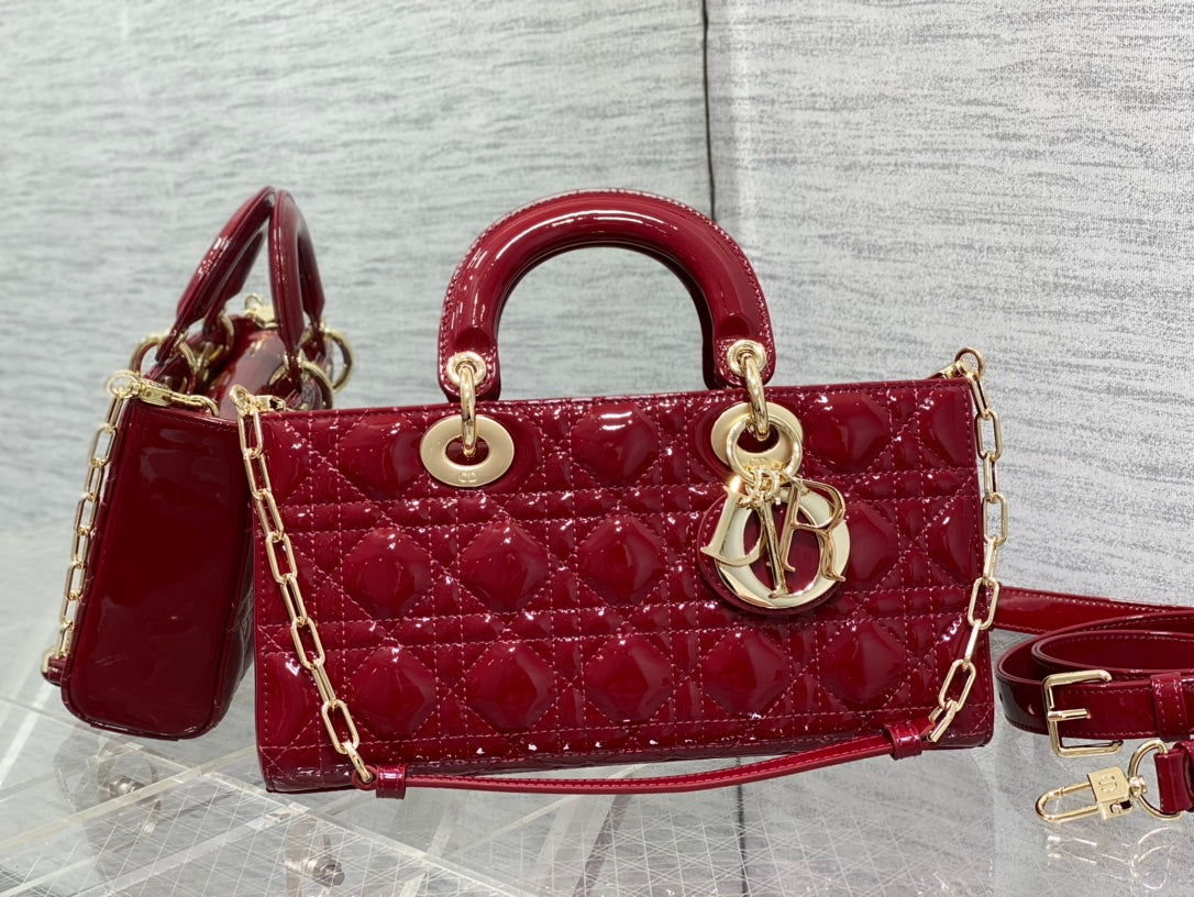 Dior handbag deep red with quilted front, curved handle, gold hardware and strap.