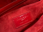Dior handbag close-up of deep red fabric lining and logo patch.