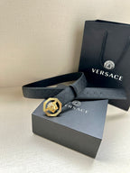 Versace belt with embossed strap and lion medallion buckle on gray box