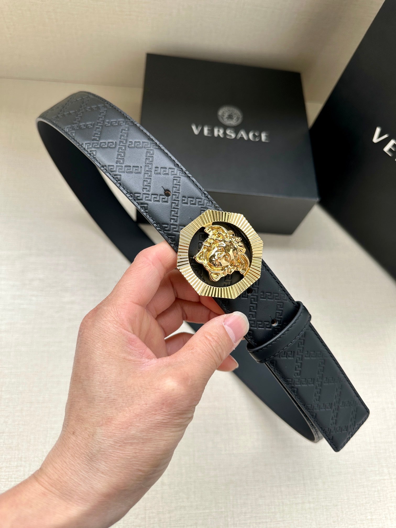 Versace belt with embossed monogram strap and ornate lion medallion buckle