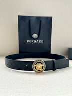 Dark leather belt with circular gold Medusa buckle and textured monogram band