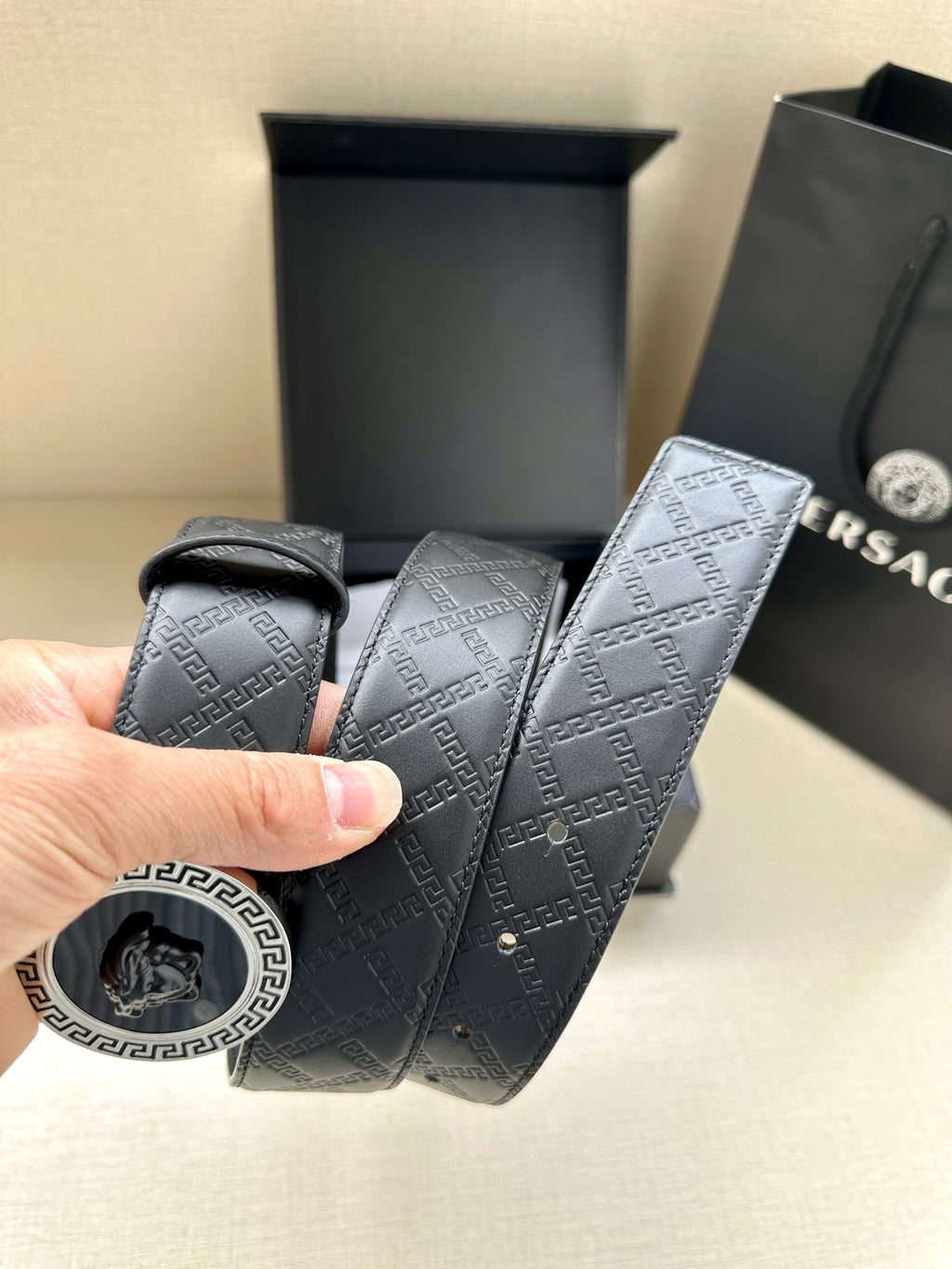 Dark navy patterned belt strap with circular buckle end and visible stitching