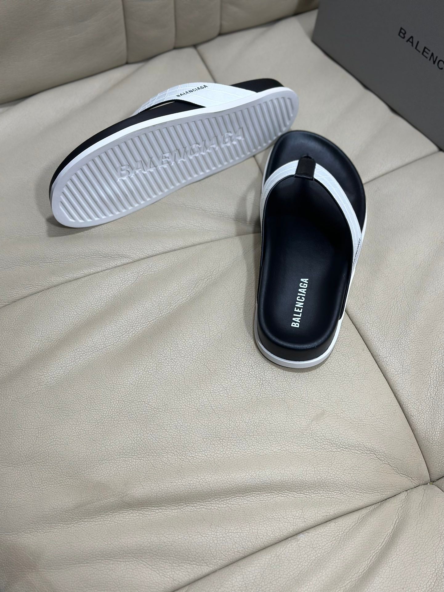 Back view of black thong sandal showing ribbed white outsole tread