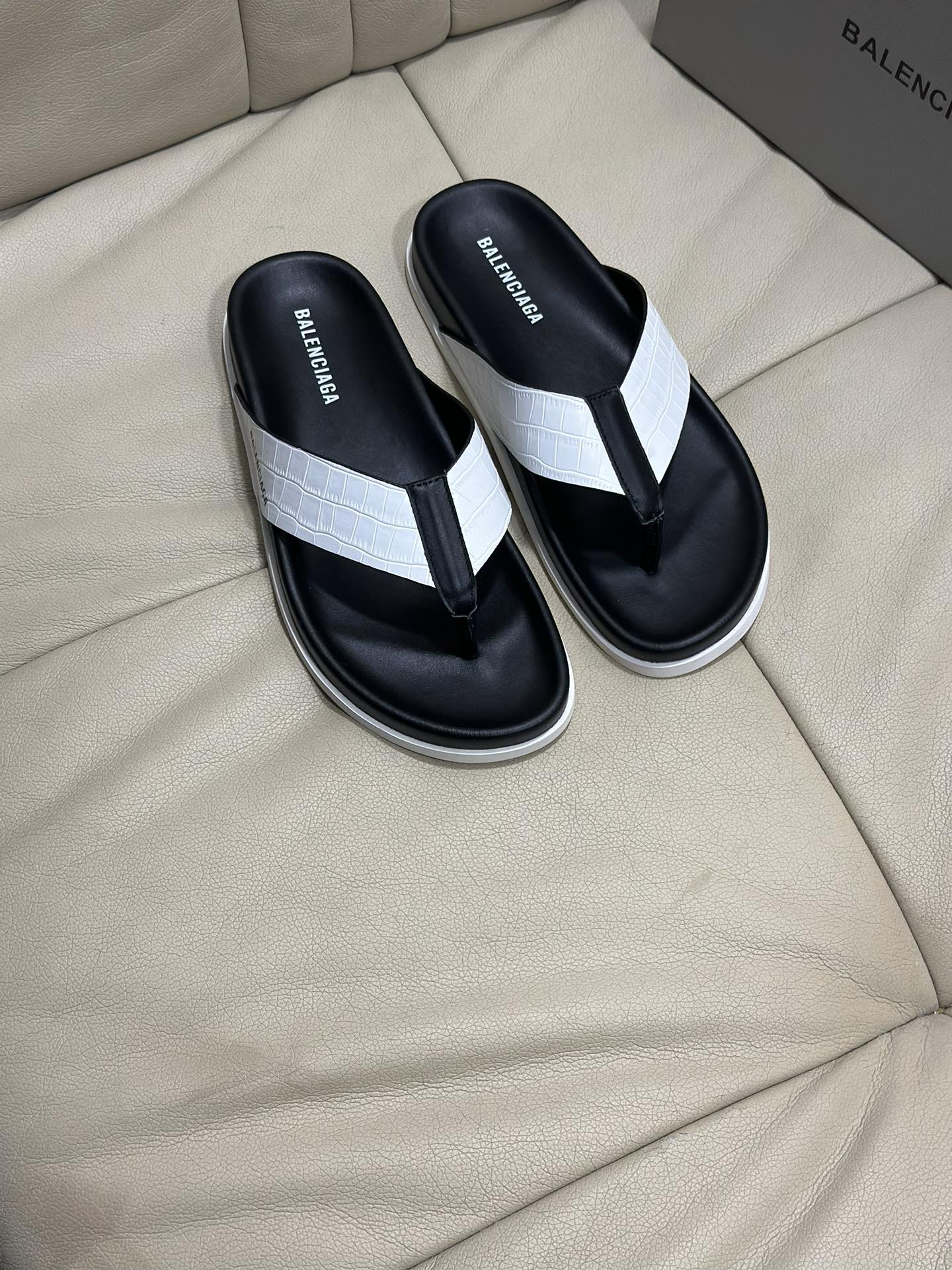 Black and white flip-flop sandals with thong strap and cushioned footbed