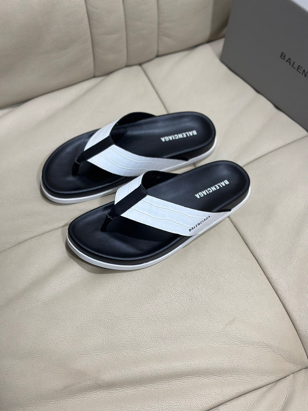 Pair of black flip-flop sandals with white cross strap and contoured sole