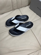 Pair of black flip-flop sandals with white cross strap and contoured sole