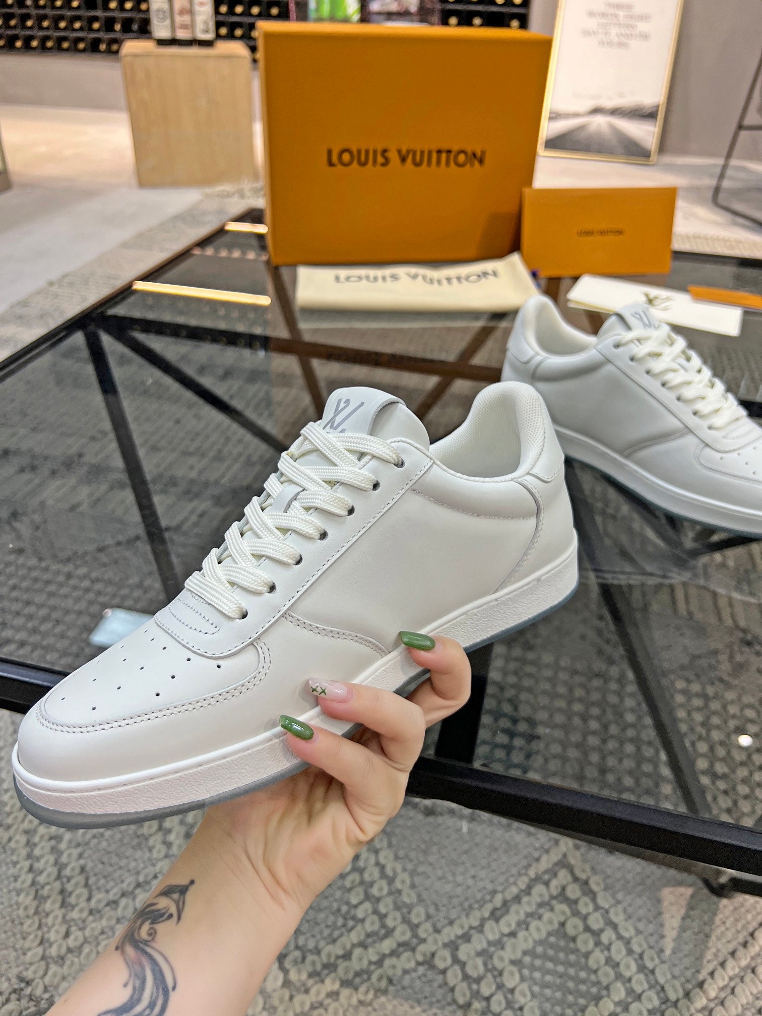 White Louis Vuitton lace-up sneakers with LV side logo and clean leather upper.