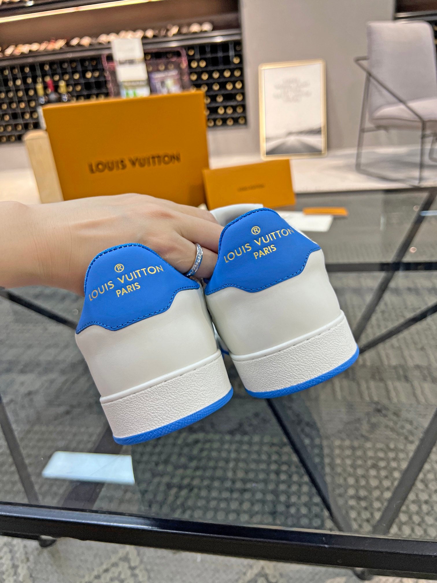 Louis Vuitton low-top sneakers, white pair with blue logo tabs on heel