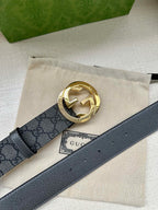 Gucci belt with dark gray GG canvas and gold-toned logo buckle on leather strap
