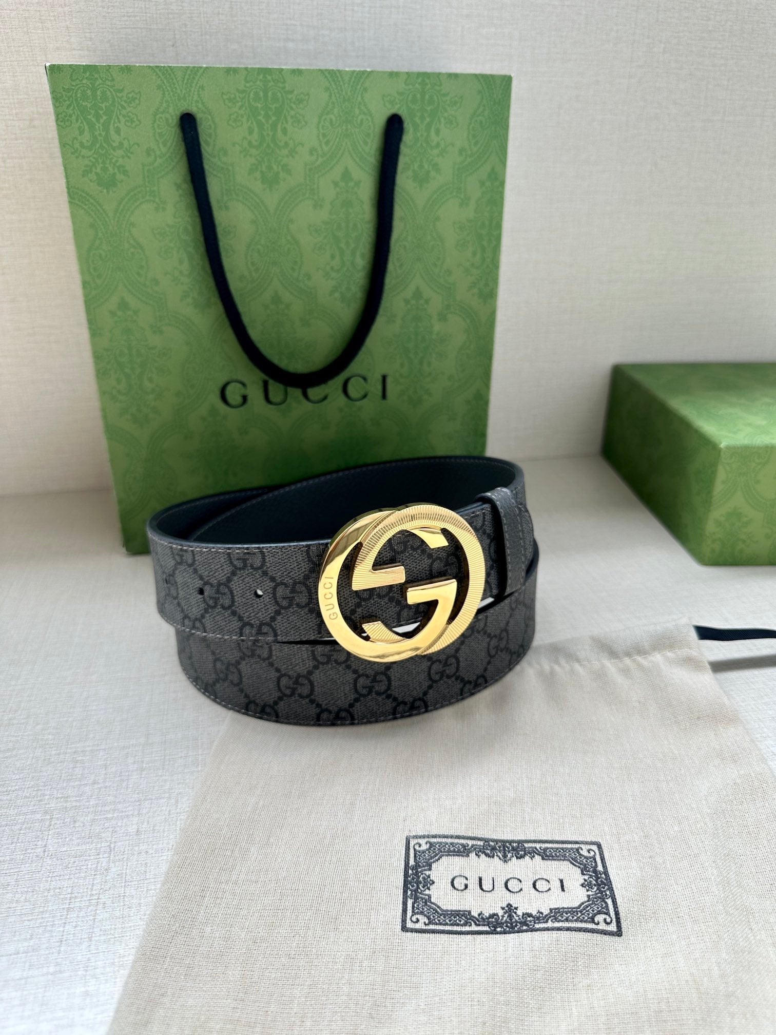 Gucci belt with dark gray GG canvas strap and gold-toned logo buckle