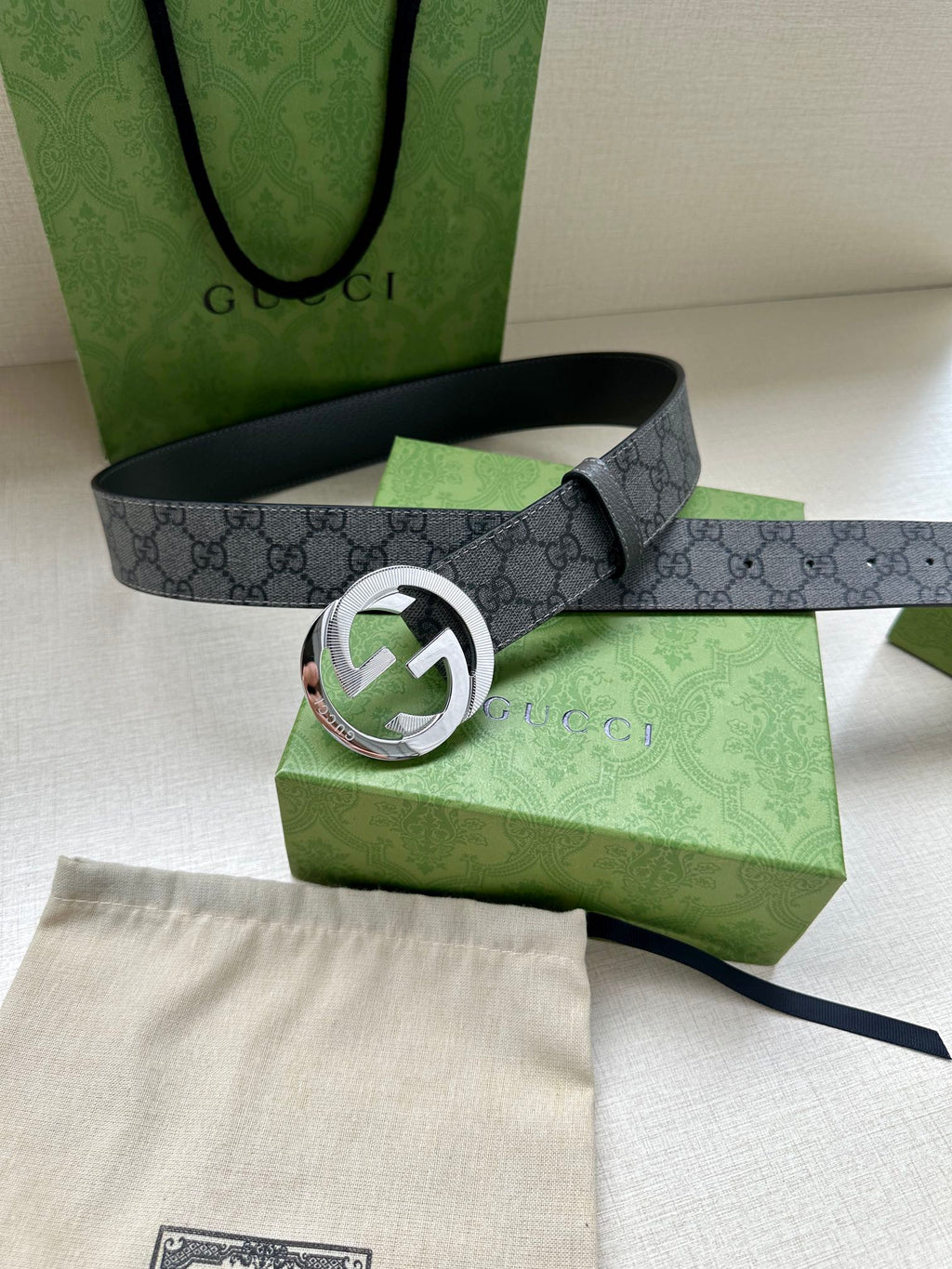 Gucci belt with dark gray GG canvas strap and large silver-toned logo buckle