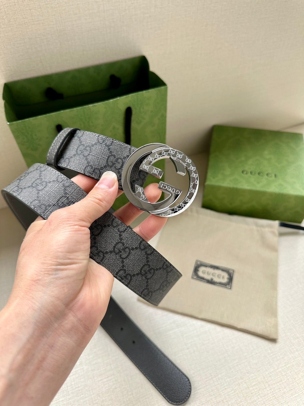 Gucci belt with dark gray GG monogram strap and large silver-tone logo buckle