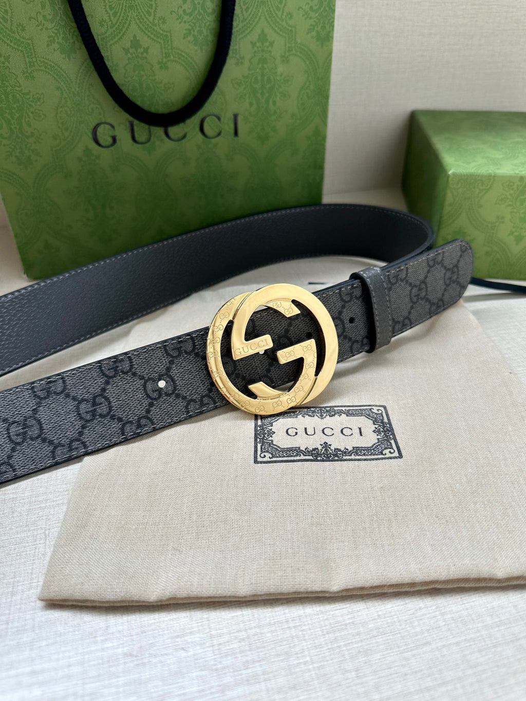 Gucci belt with dark gray GG monogram strap and gold-tone interlocking G buckle