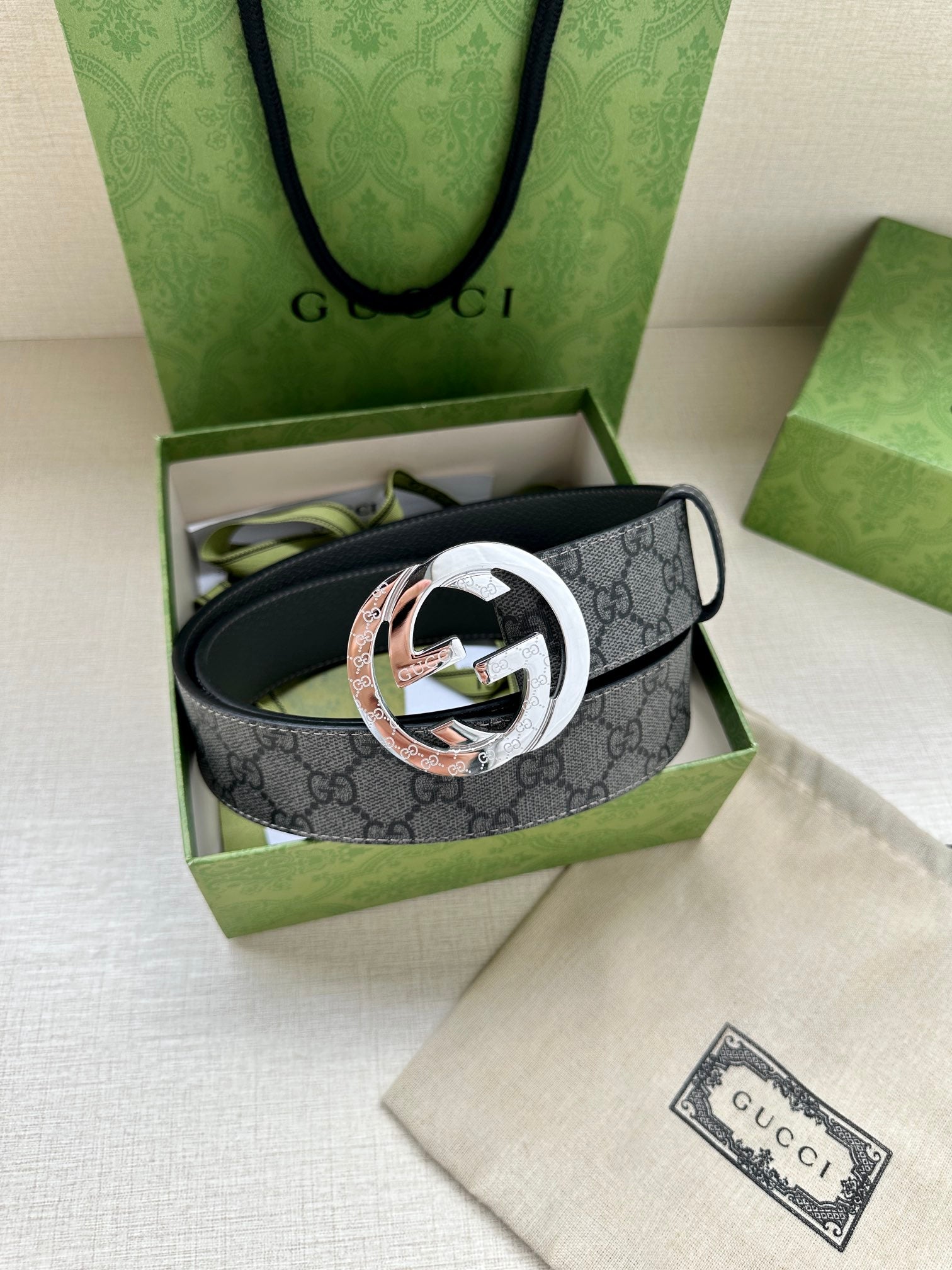 Gucci belt with dark gray GG monogram strap and multitone silver and rose logo buckle