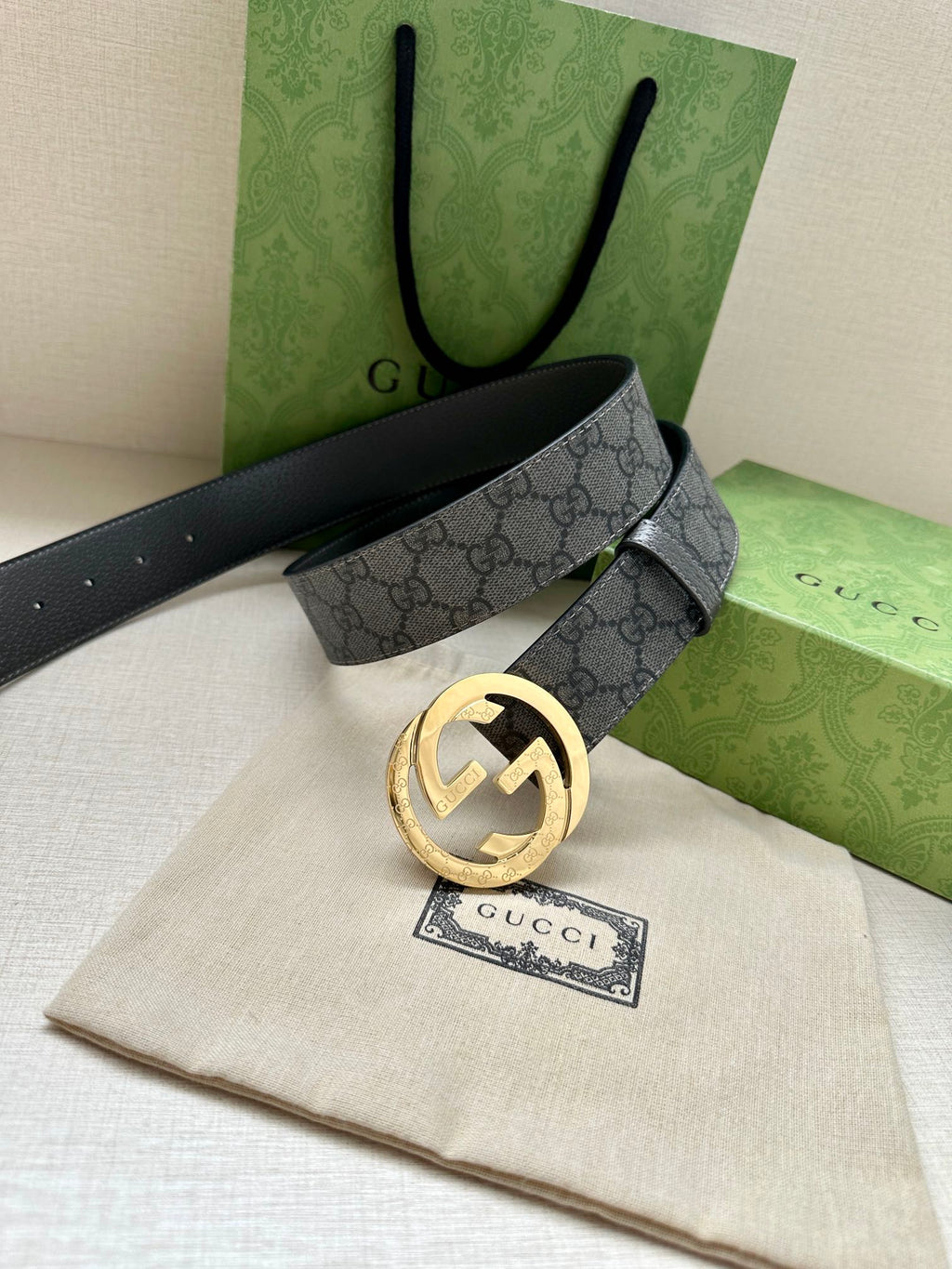 Gucci belt with dark gray GG monogram strap and gold-tone round logo buckle