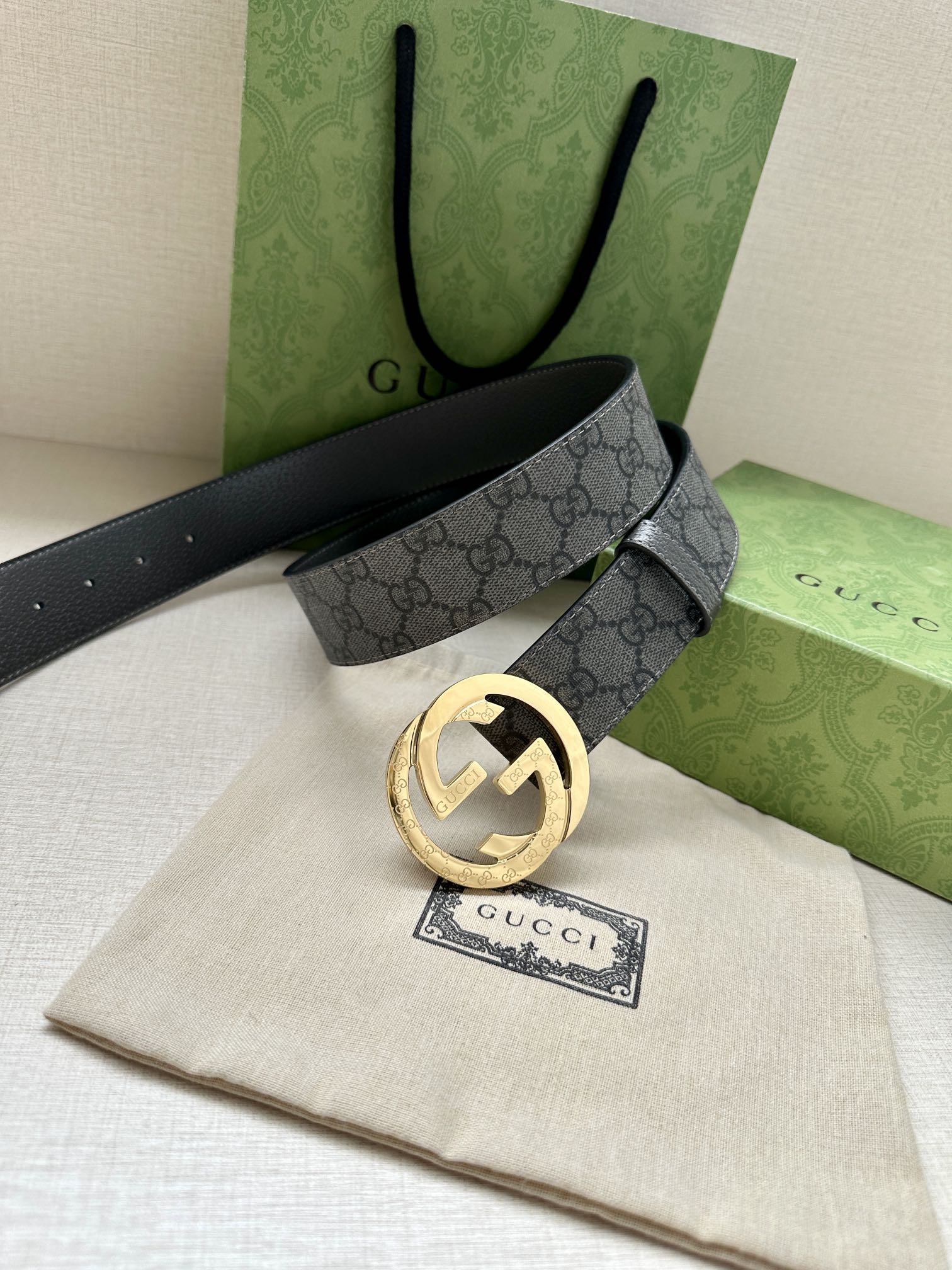 Gucci belt with dark gray GG monogram strap and gold-tone round logo buckle