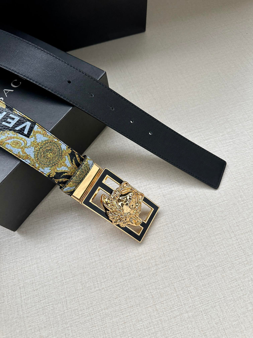 Versace belt with gold-and-blue patterned strap and gold square buckle detail