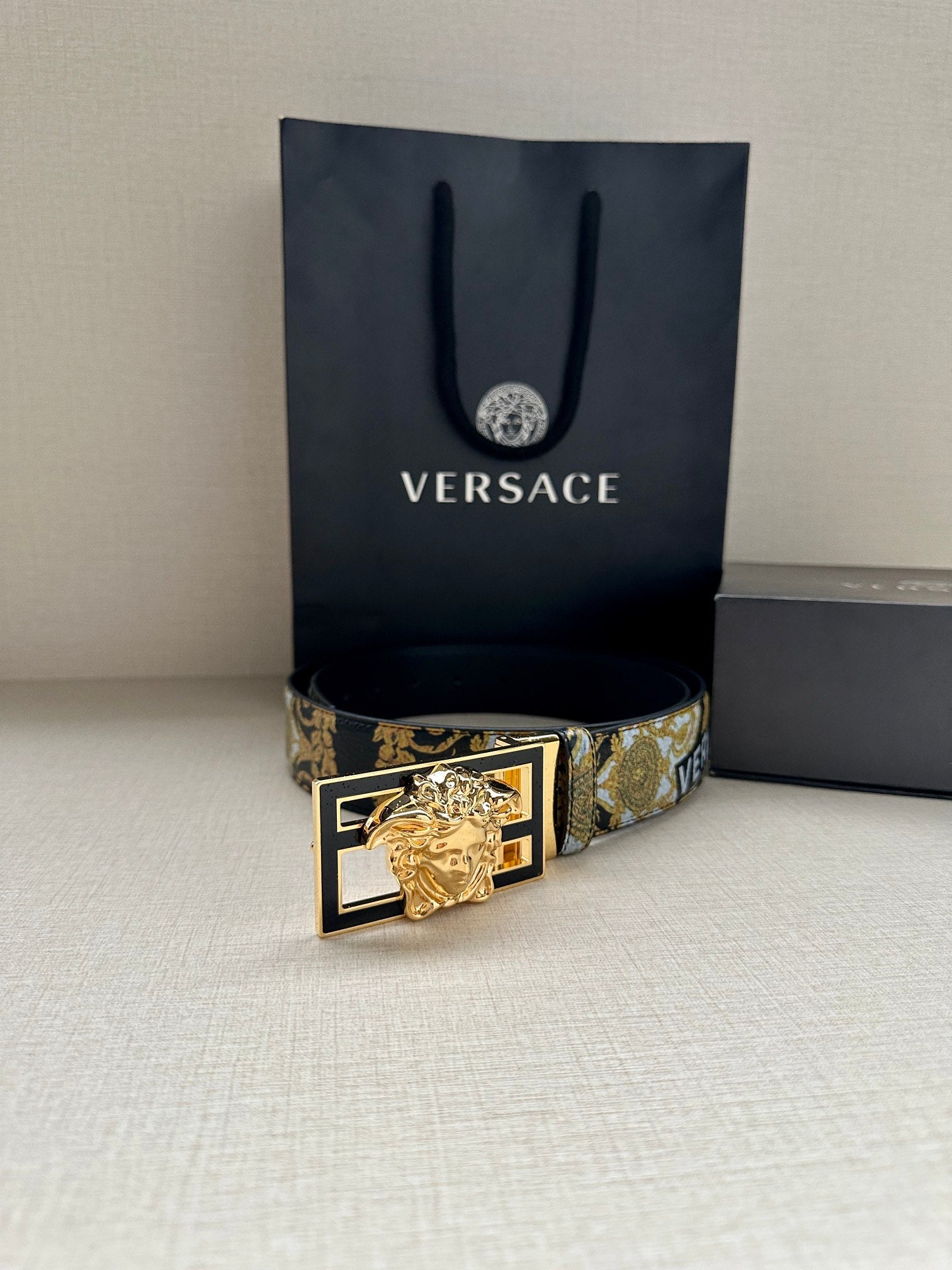 Versace belt with gold-blue patterned strap and gold lion buckle, front view