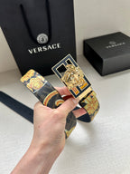 Designer belt with navy patterned strap and gold decorative buckle