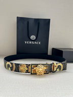 Designer belt on white surface with navy patterned strap and gold buckle