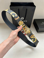 Designer belt held up: navy baroque patterned strap with gold medallion buckle
