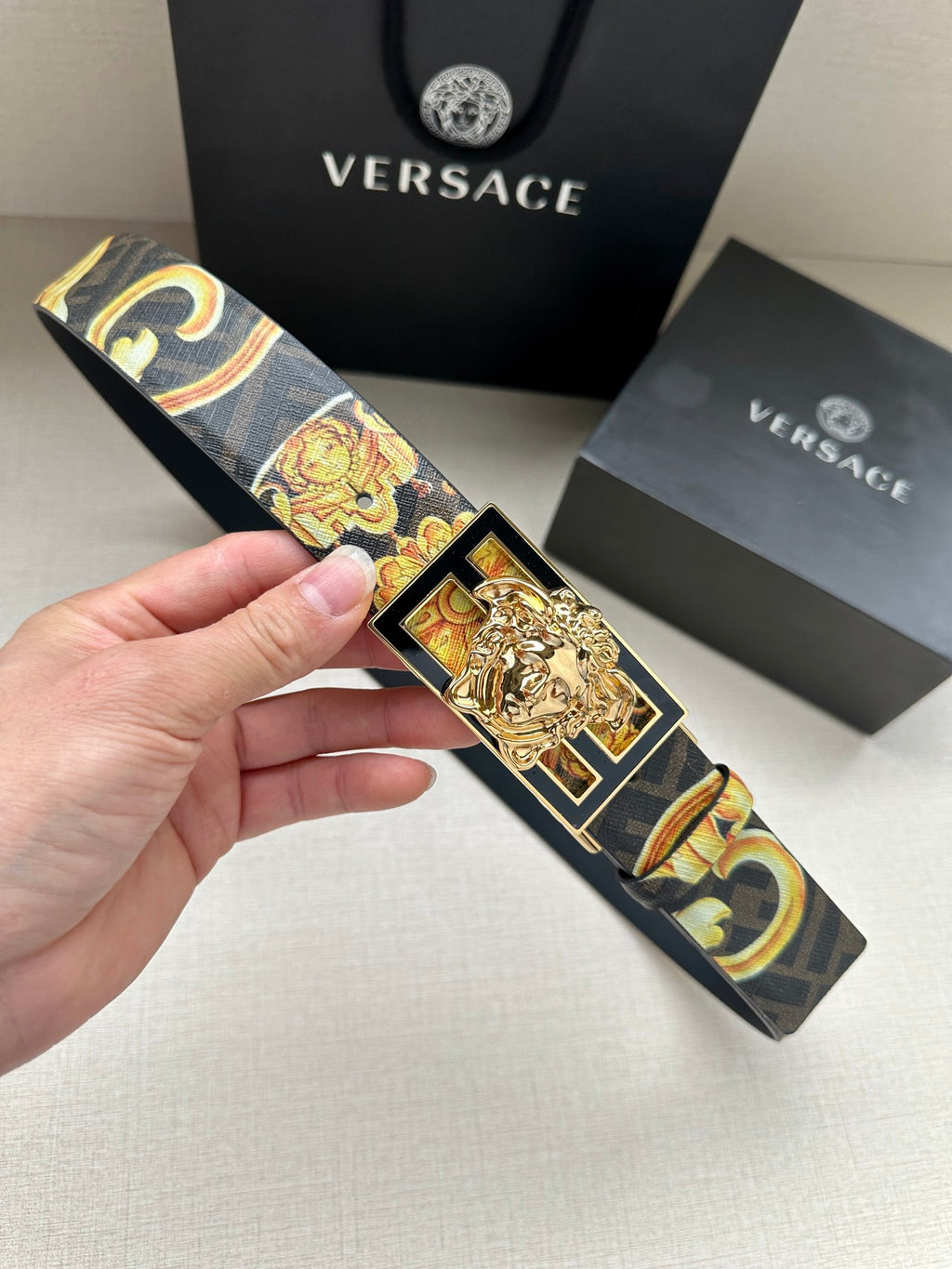 Designer belt with navy patterned strap and gold baroque medallion buckle