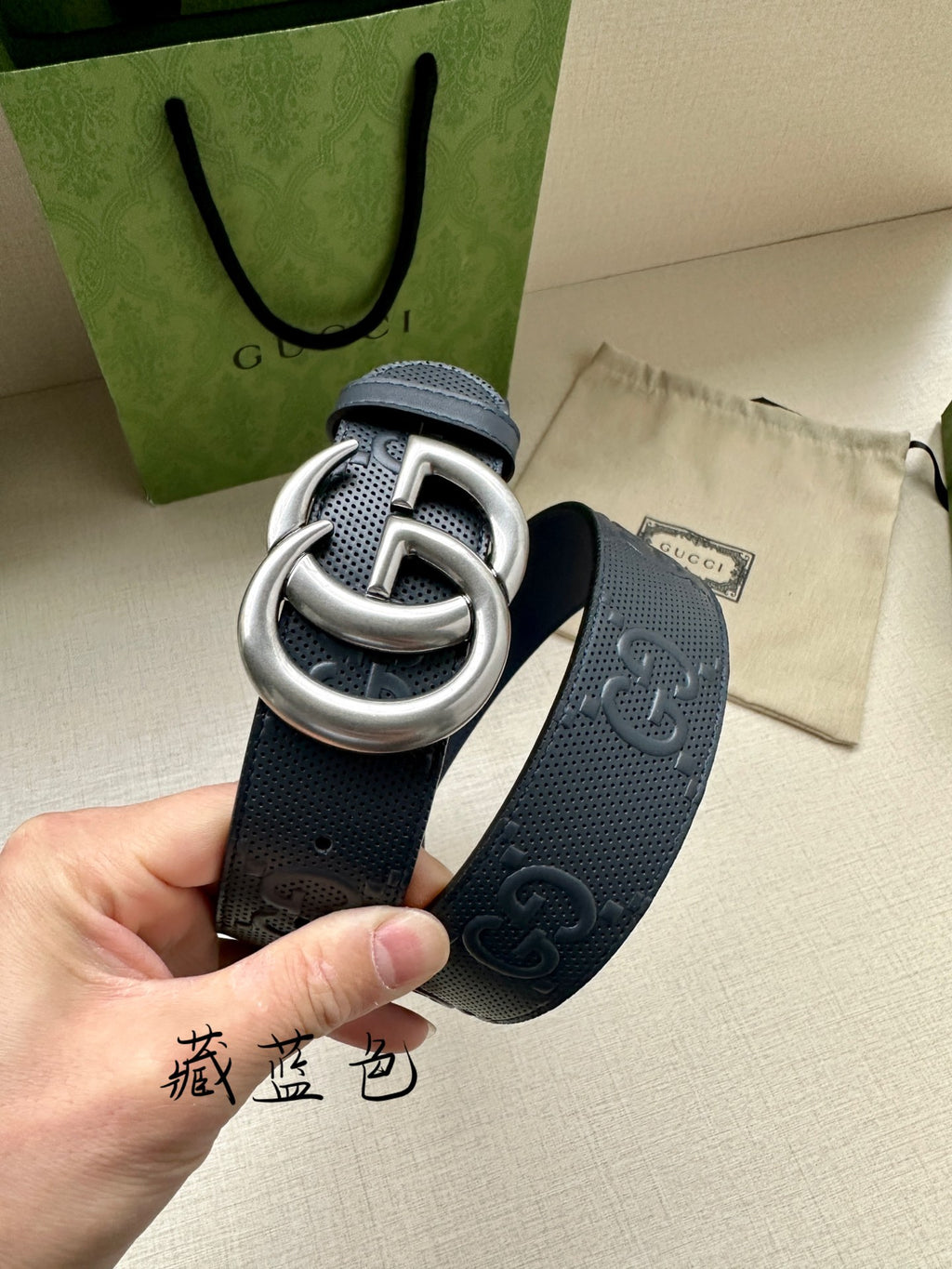 Gucci belt strap detail in dark navy with embossed GG pattern and silver double G buckle