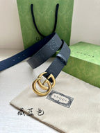 Gucci belt angled view, dark blue strap with embossed GG and gold-tone buckle