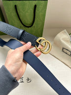 Gucci belt detail: dark blue leather strap with embossed GG and gold-tone buckle