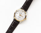 Rolex wristwatch with white dial, gold hands, black leather strap