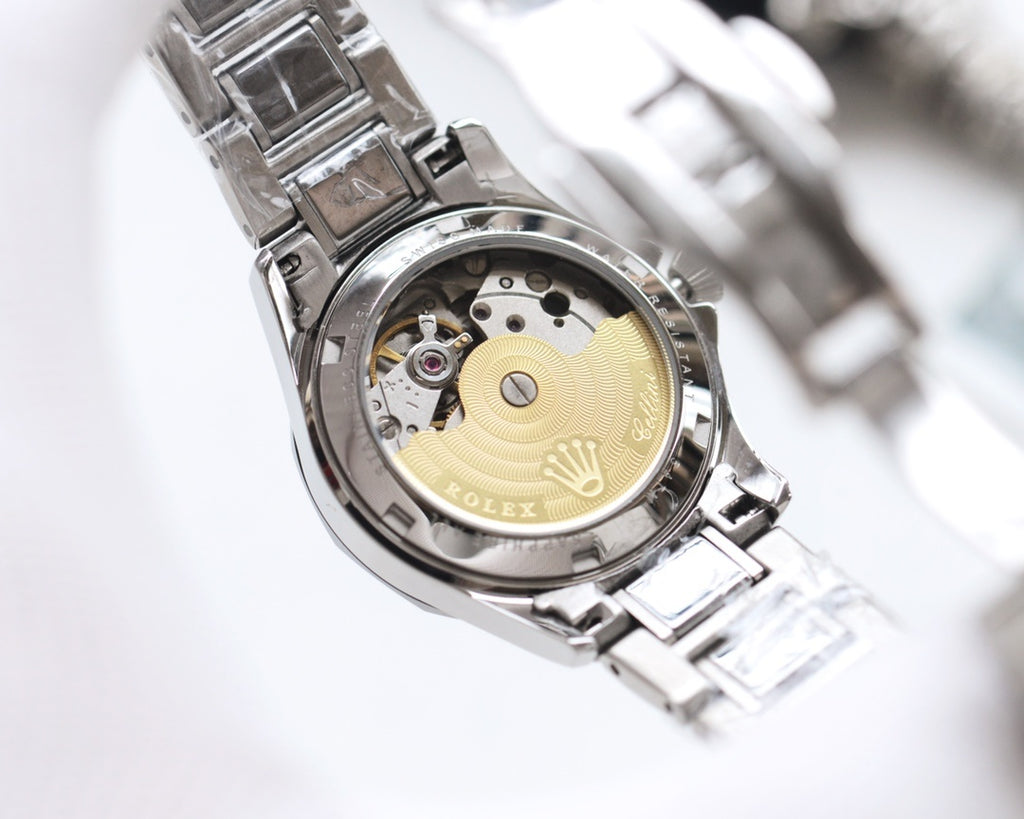 Rolex wristwatch with exposed mechanical movement, gold-toned plate, stainless caseback.