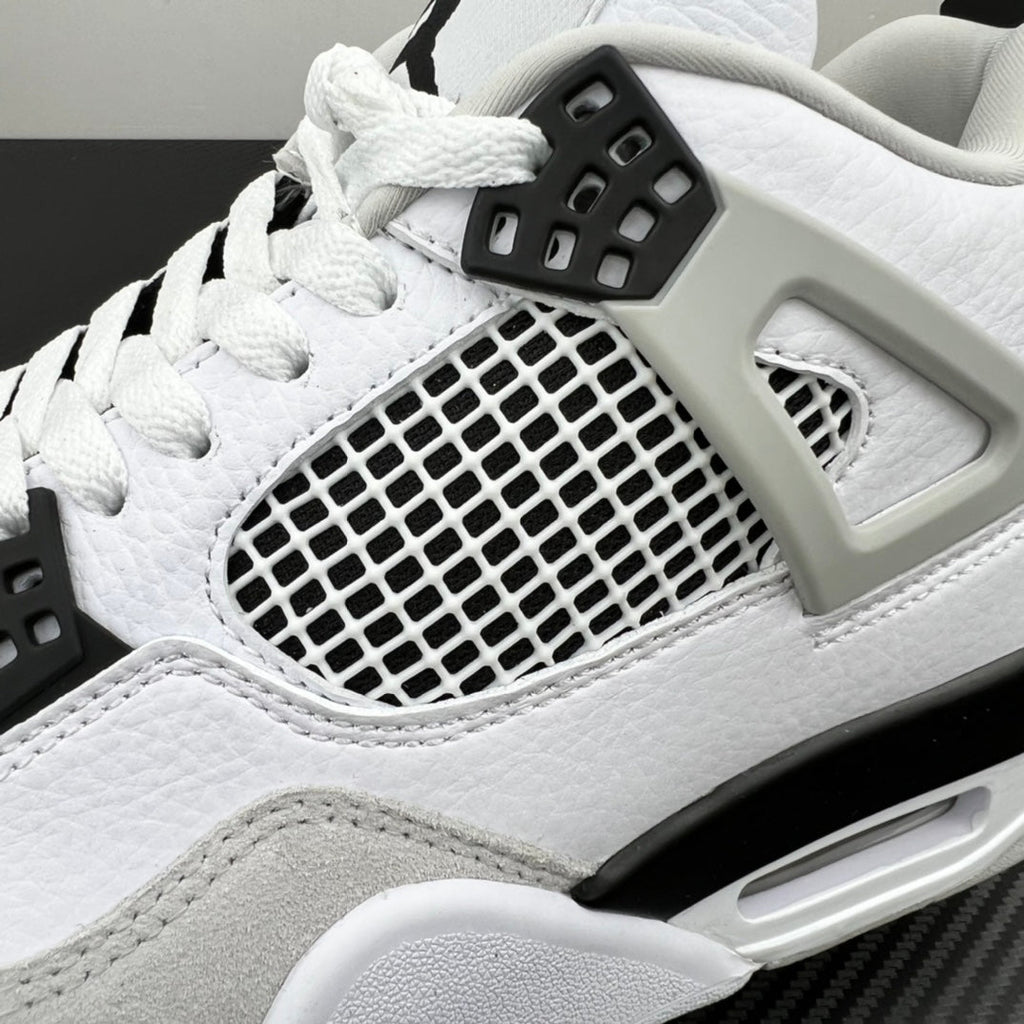 Close-up Air Jordan 4 with white leather texture, mesh window, and black lace lock
