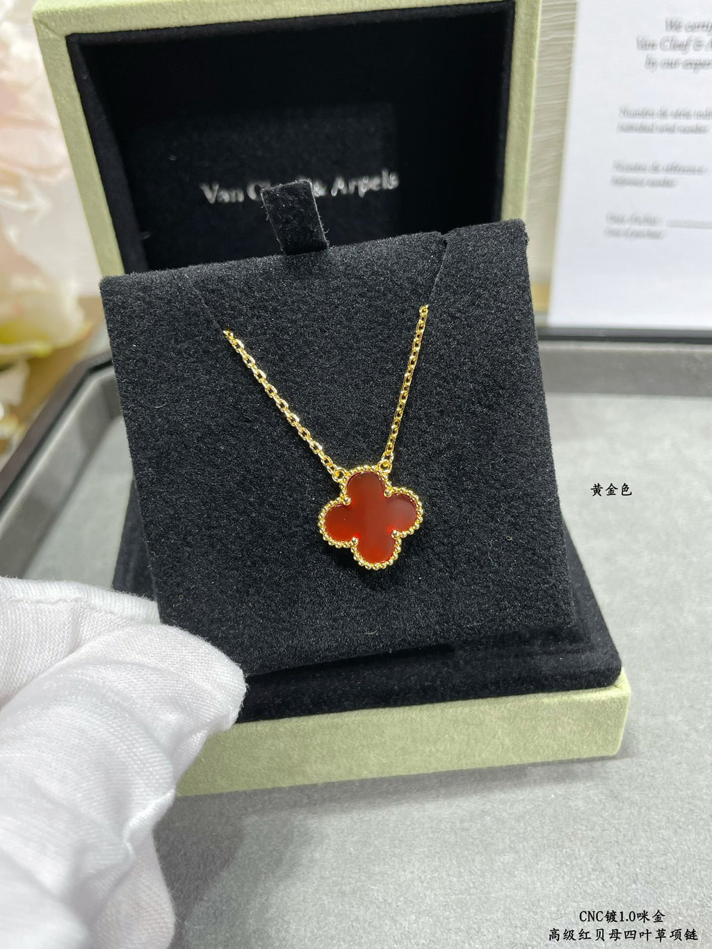 Gold clover pendant necklace on black jewelry box