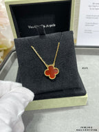 Gold clover pendant necklace on black jewelry box