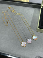 Multi-necklace display with clover pendants in gold and silver tones.